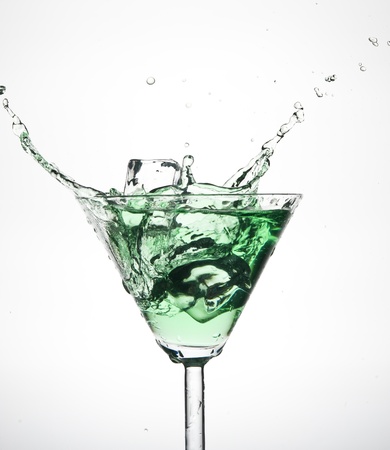 Splashing green cocktail in martiniglassの写真素材