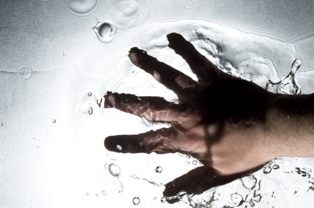 Hand on the Black water . Creative splashing dark water
