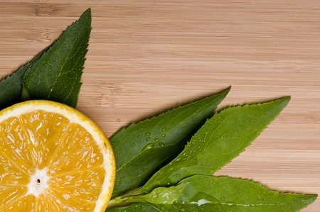 Orange with leaves on the wood backgroundの写真素材