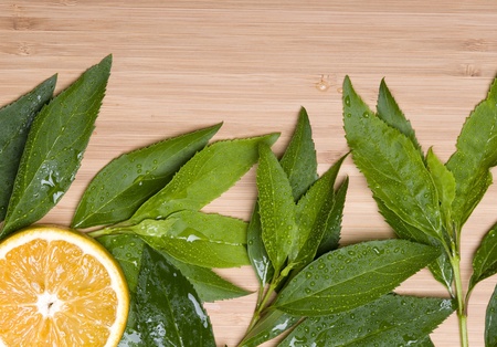 Orange with leaves on the wood backgroundの写真素材