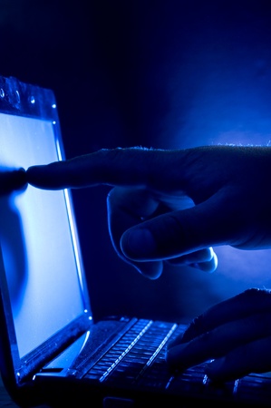 Laptop and human hand on blue background
の写真素材