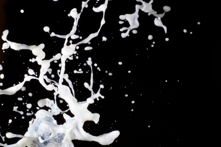 Splashing milk on  the black backgroundの写真素材
