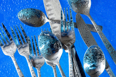 A group of dinner forks. Blue background with kitchen utensil