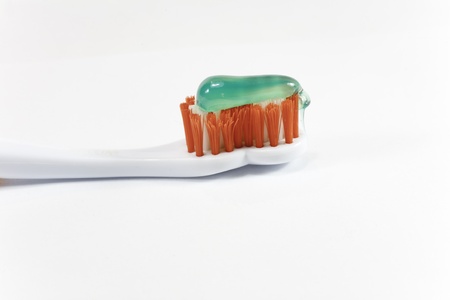 a toothbrush orange with green toothpasteの写真素材