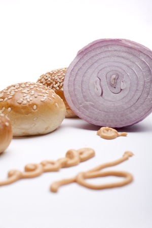 an onion along with some hamburger buns and sauceの写真素材