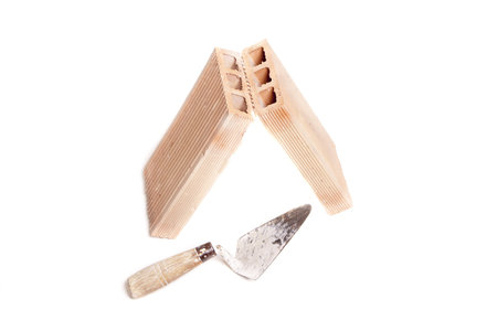 two bricks and a shovel, representing the contruction of a houseの写真素材
