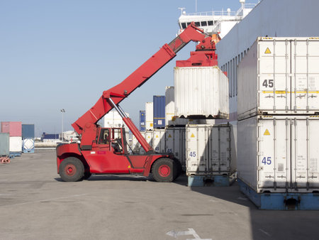 a crane, loading containers on a loading dock