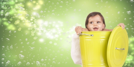 a baby tucked into a green binの写真素材