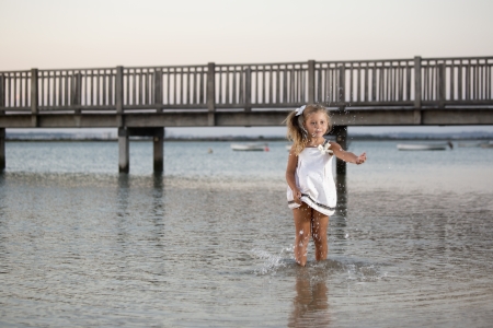 a beautiful girl, posing on a beach at sunsetの写真素材