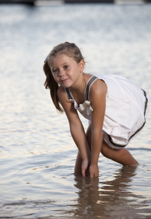 a beautiful girl, posing on a beach at sunsetの写真素材
