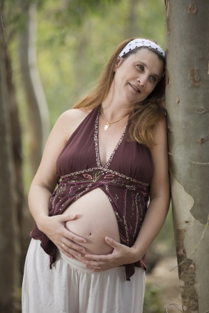 a pregnant woman in a beautiful forest in autumnの写真素材