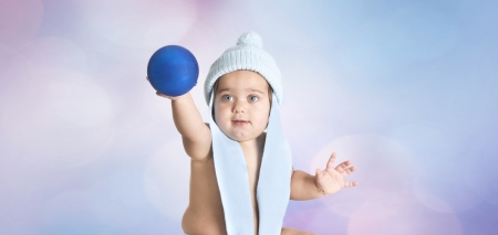 a little girl playing with blue christmas ballの写真素材