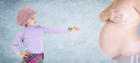 girl playing darts in the belly of his pregnant motherの写真素材