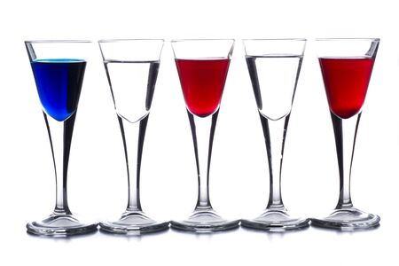 several shot glasses with different drinks, which combined represent the flag of a countryの写真素材
