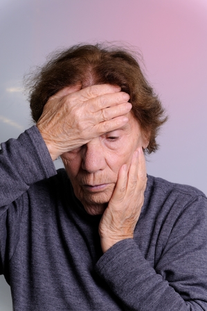 elderly woman with hand on her faceの写真素材