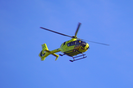 Almere, Netherlands - October 5, 2018: Dutch Ambulance Helicopter (Lifeliner 1) flying by against a clear blue sky.