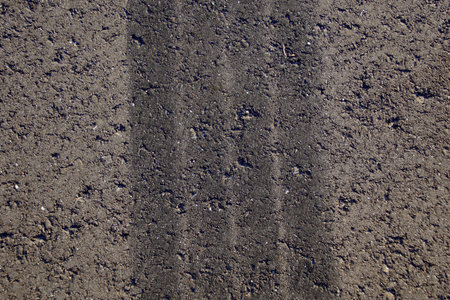 Black tire track on gray asphalt.