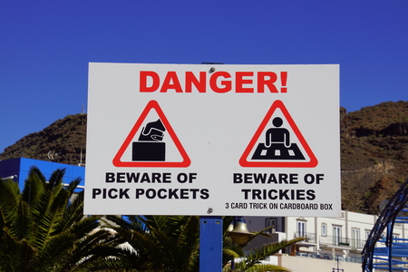 Puerto de Mogan, Gran Canaria, Spain - December 31, 2018: Tourist information sign warning sign for Pick Pockets and 3 card trick.のeditorial素材