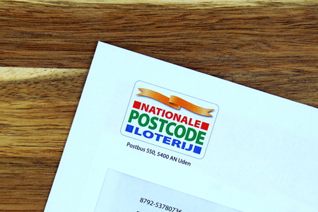Amsterdam, the Netherlands - January 17, 2019: Dutch lottery (Postcode Lottery) on a envelope against a wooden background.のeditorial素材