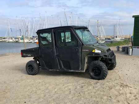 Lelystad, Flevoland, the Netherlands - May 31, 2019: Green Polaris Ranger Crew parked on a beach....