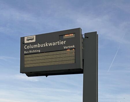 Almere Poort, the Netherlands - November 24, 2019: Dutch bus departure information board against a blue sky.のeditorial素材
