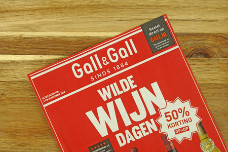 Amsterdam, the Netherlands - November 1, 2020: Dutch Liquor store Gall and Gall sale flyer, against a wooden background.