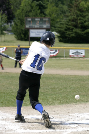 Little leaguer swinging and missing a pitch