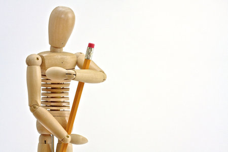 Wooden manikin holding pencilの写真素材
