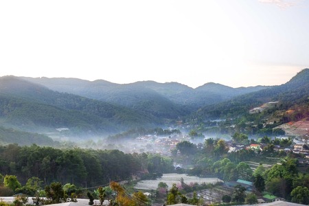 Morning mist into the village in the valleyの写真素材