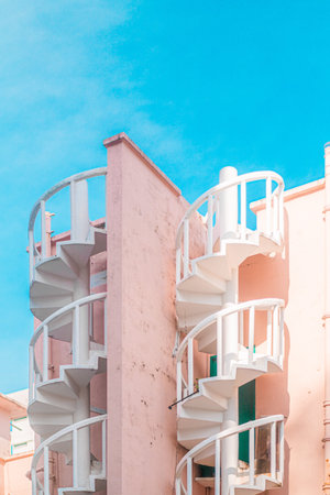 White spiral stair with blue sky background - Vintage filter and sunflare effect
