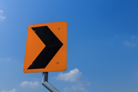 Yellow hazard sign of road curved on blue backgroundの写真素材
