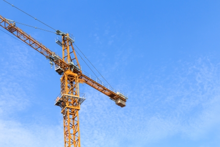 yellow hoisting crane and blue sky backgroundの写真素材