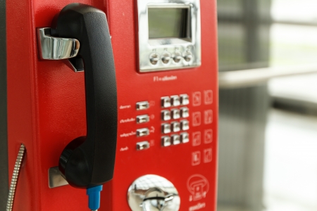 Red public telephone on the wall at airport terminalの写真素材