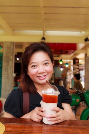 Happy woman with tea in coffee shopの写真素材