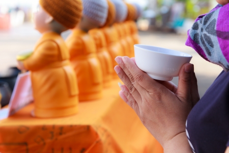 Portrait of Buddhist woman praying and young monk statue の写真素材