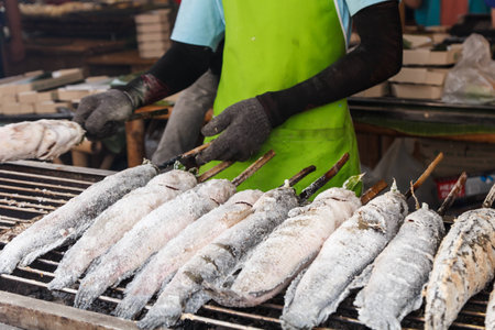 BBQ fish with salt in the market and seller backgroundの写真素材