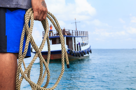 Fisherman prepare the rope for stop boatの写真素材