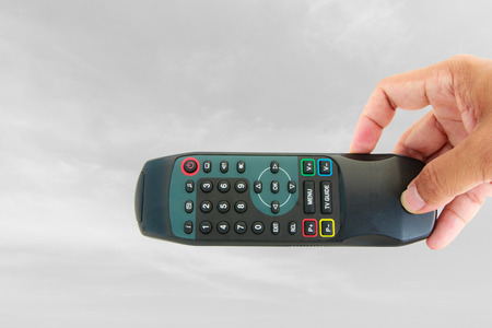 Hand show remote control on sky backgroundの写真素材