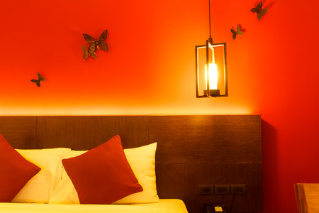 Bedroom with lamp on the wall above the bedの写真素材