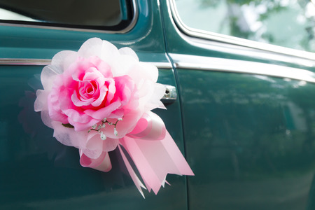 Flower arrangement tied to a wedding carの写真素材