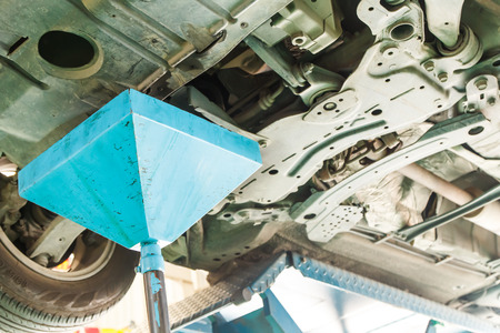 Changing motor oil to engine at car serviceの写真素材