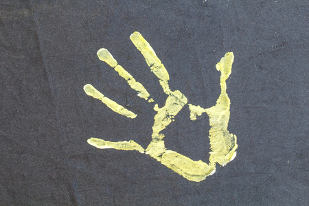 Yellow hand paint on black backgroundの写真素材