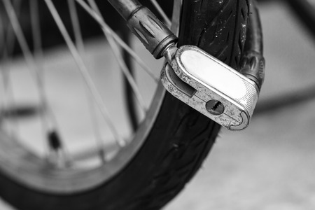 Security lock blocking the bicycle wheel in parkの写真素材