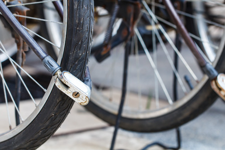 Security lock blocking the bicycle wheel in parkの写真素材