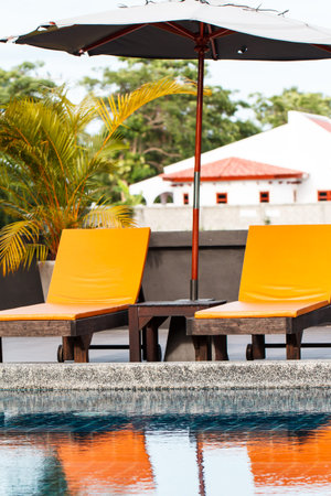 View of swimming pool and orange benchのeditorial素材