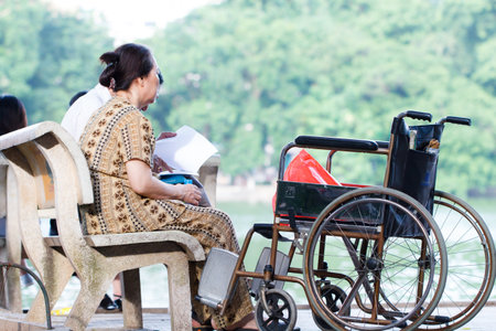 VIETNAM-JUNE 25: Vietnam senior woman in a wheelchair at the park, they came to relax, JUNE 25, 2014 in Hanoi, Vietnamのeditorial素材