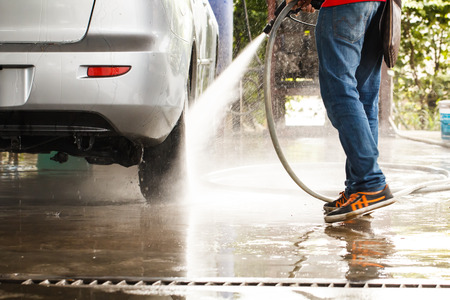 Worker washing car in the carwashの写真素材