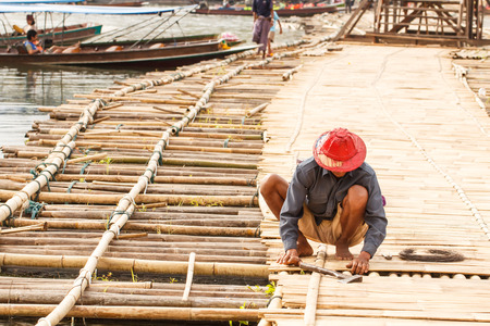 Worker repair bamboo bridge in Sangkhlaburi, Thailandの写真素材