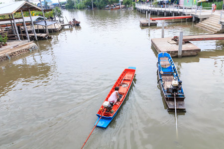 Old woman driving the red small boat on the riverのeditorial素材