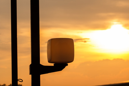 Silhouette of lamp on beautiful orange sunset sky backgroundの写真素材